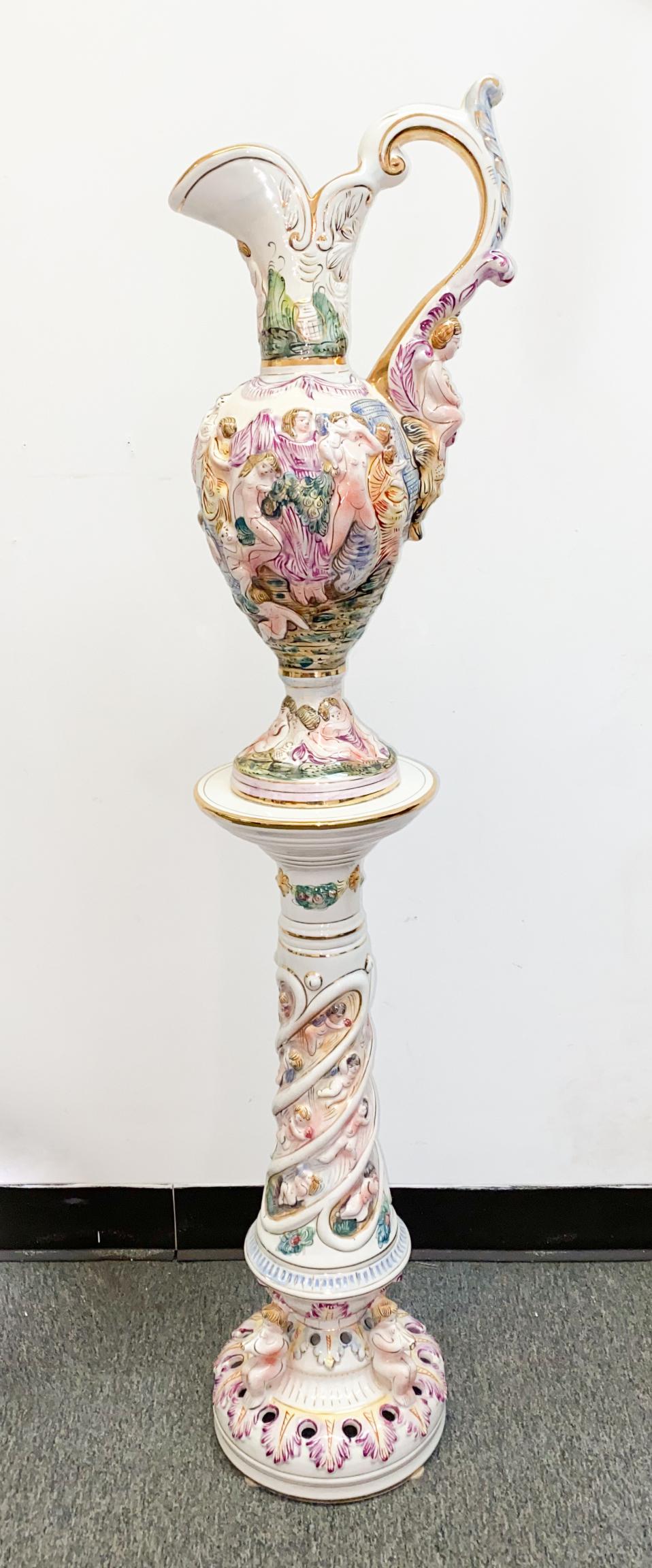Capodimonte Porcelain Stand w/Handled Ewer: Late 19th/early 20th century Capodimonte porcelain stand accompanied with handled ewer; both in pastel palette with gilt highlights throughout and playful putti and figural scenes in relief. Both with