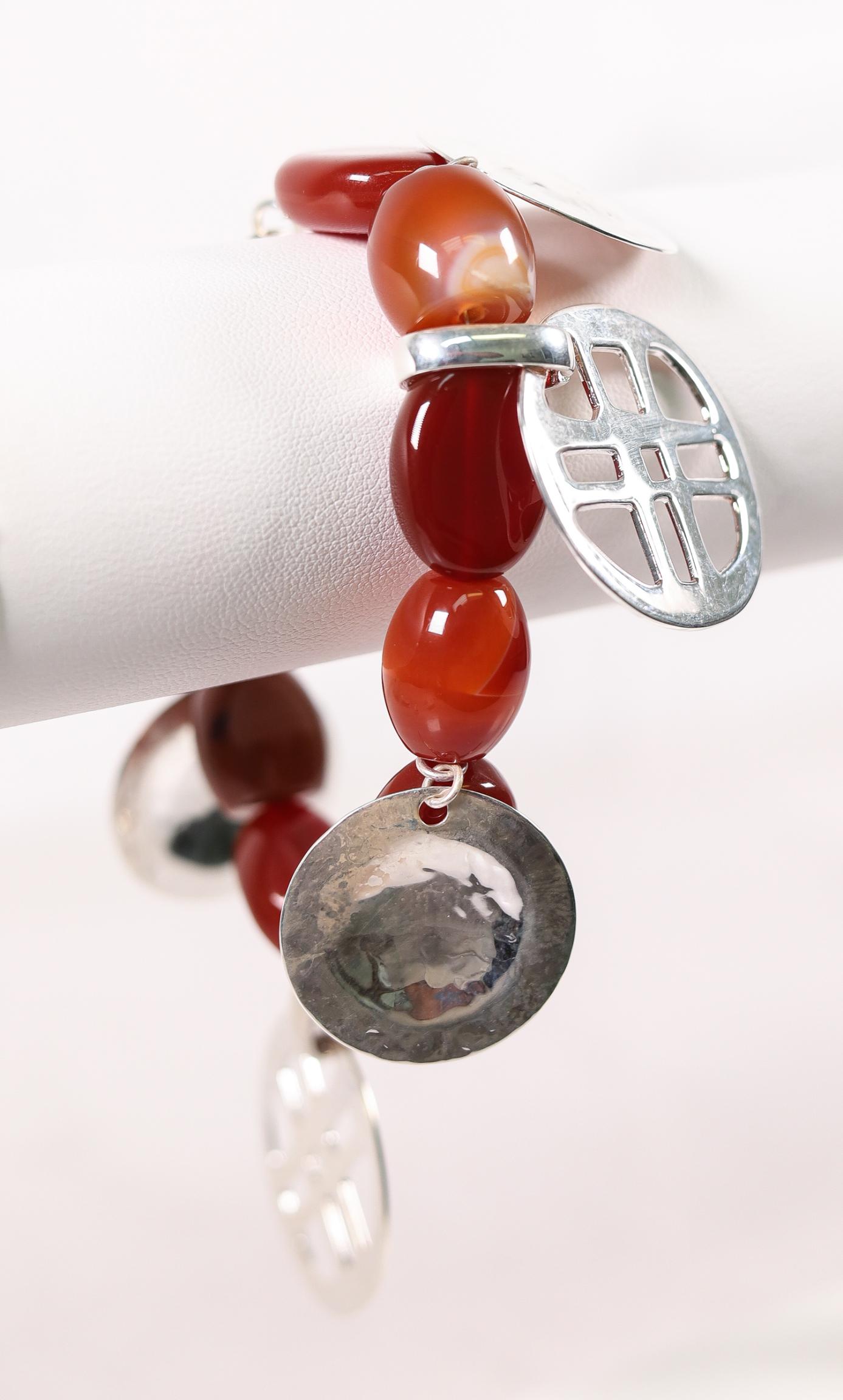 RLM STUDIOS STERLING SILVER CARNELIAN BRACELET: Robert Lee Morris Studios sterling silver bracelet hung with sterling silver charms and cabochon carnelian beads. Stamped RLM Studios 925 China. Approx. length 7in., weight 60 grams.