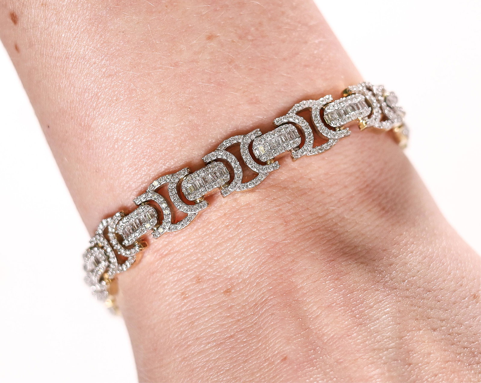 YELLOW GOLD 5.6CTW VS1 DIAMOND TENNIS BRACELET: 10K yellow gold tennis bracelet set with 5.6ctw VS1 round diamonds and tapered baguette diamonds. Has safety clasp. Stamped 10K GND. Approx. length 8.75in., weight 32 grams.