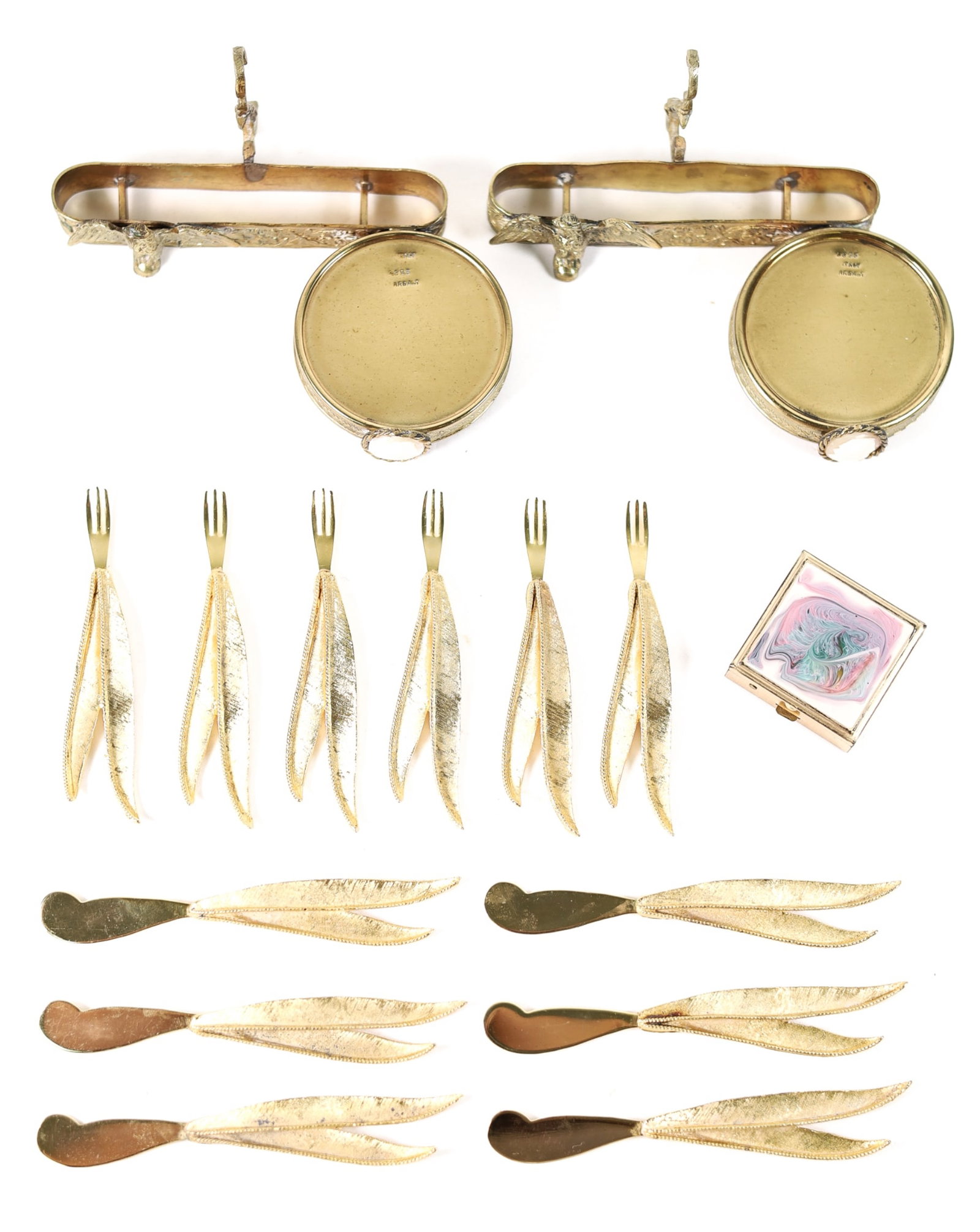 GROUP, GOLD TONE TABLE ACCESSORIES: Group of gold tone table accessories comprising six Janis Collection 24k gold plated Hors D'oeuvres forks and six spreader knives; 1.62 inch square gold box with enameled lid; two Ardalt Italy tea cup