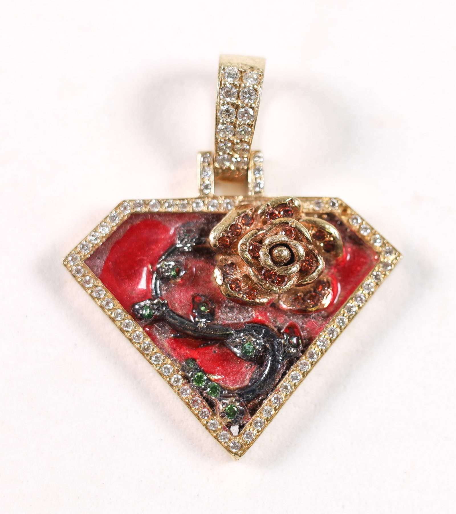 YELLOW GOLD .80 CTW DIAMOND SUPERMAN PENDANT: 10K yellow gold superman flower pendant set with .80 ctw multi color diamonds and red enamel. Apparently unmarked but tested for 10K gold purity. Approx. length 1.5in. including bail, weight 11.2 gram