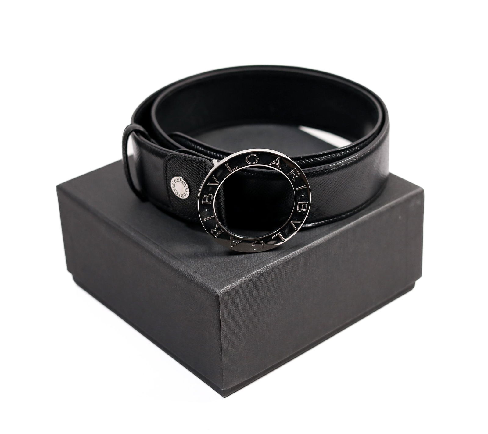 BVLGARI BLACK LEATHER BELT W/BAG & BOX, 38 IN.: A Bvlgari black leather belt. This belt features a silver-toned buckle and the iconic Bvlgari logo. The belt is in good condition with only minor wear. It comes with its original box and storage bag.