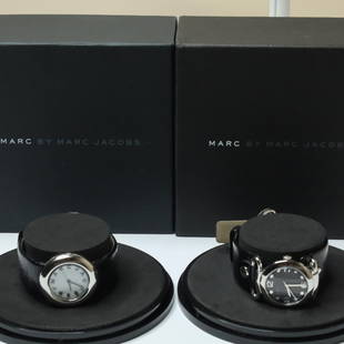 SET OF 2 MARC BY MARC JACOBS WATCHES W/BOXES: Two Marc by Marc Jacobs watches in good condition. One watch has a white dial, while the other has a black dial. Both watches have a stainless steel case and a black leather band. Each comes in its or