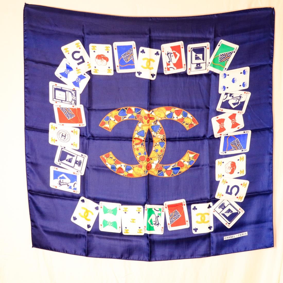 CHANEL PLAYING CARDS SCARF, 34IN.: Chanel playing cards scarf in good condition. It features a playing card design with a navy background. Details and measurements: Dimensions: 34 IN. X 34 IN.