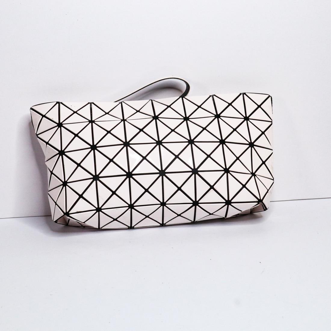 ISSEY MIYAKE BAO BAO CLUTCH BAG: Issey Miyake Bao Bao clutch bag in good condition. It features a handle and silver-toned hardware. There is minor wear, but the clutch is still in good condition. The inside includes a Bao Bao leather