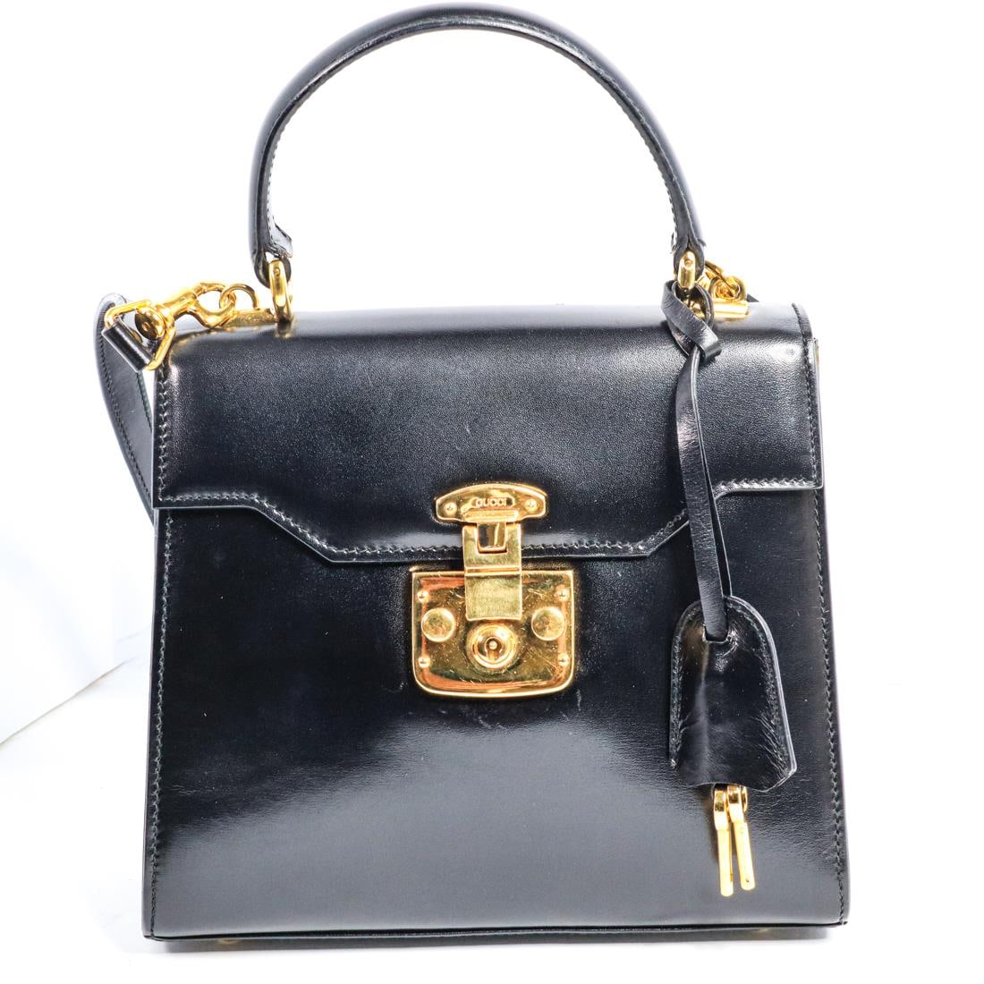 GUCCI LADY LOCK SHOULDER BAG: Gucci Lady Lock shoulder bag in excellent condition. It features a leather handle, a shoulder strap, gold-toned hardware, four feet, a lock, and two keys. There are minor scratches on the exterior and