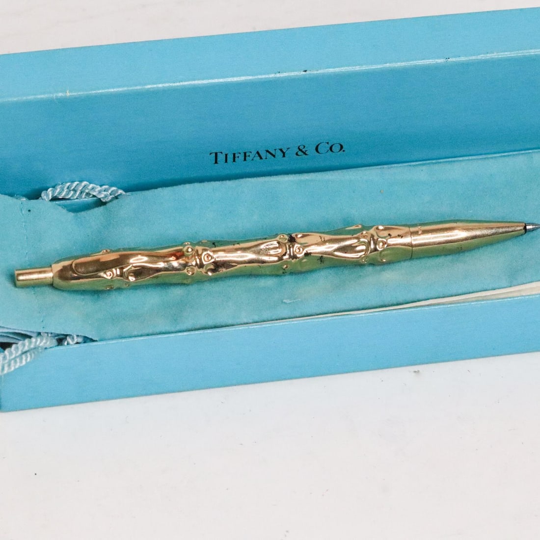 TIFFANY & CO. 14KYG BAMBOO BALLPOINT PEN W/BOX: Tiffany & Co. vintage 14-karat solid yellow gold bamboo ballpoint pen. The clicker mechanism is stuck. With box and dust bag. Marked 14K on the pen. Details and measurements: Pen length: 5 IN. Weight: