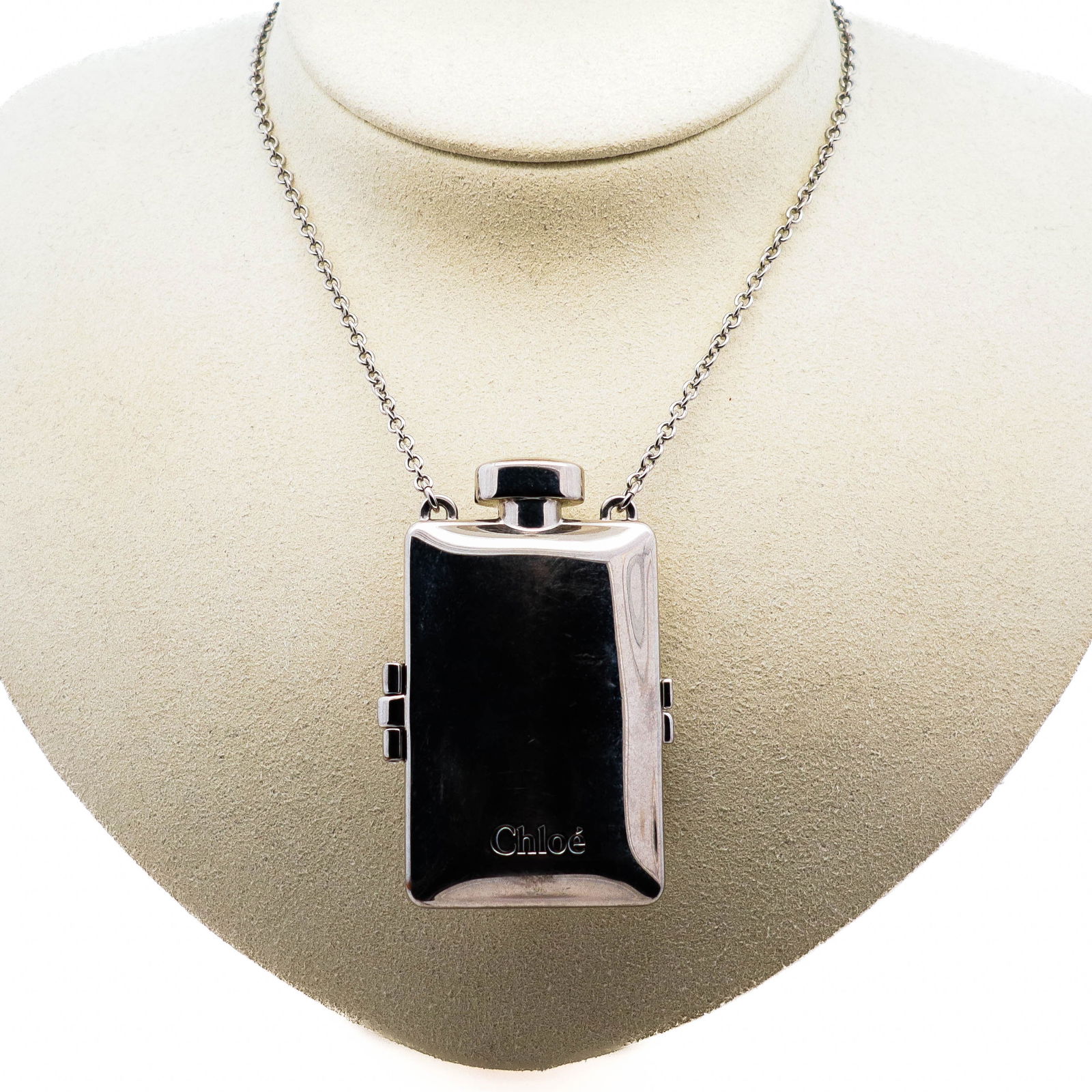 Chloe Solid Perfume Pendant Necklace – Silver Tone: Chloe silver-tone necklace featuring a miniature perfume flask pendant designed to hold solid perfume. Stylish and functional, this piece combines accessory and fragrance in one. Chain with lobster cl