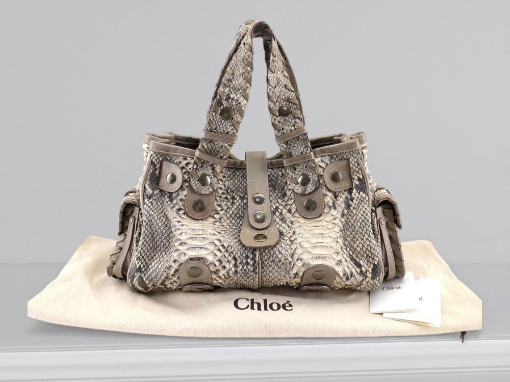 Chloé Silverado Natural Python Leather Handbag: Chloé Silverado handbag having a structured satchel form and two rolled top handles. Featuring natural python leather exterior with tonal stitching and layered panel construction. Set with leather st