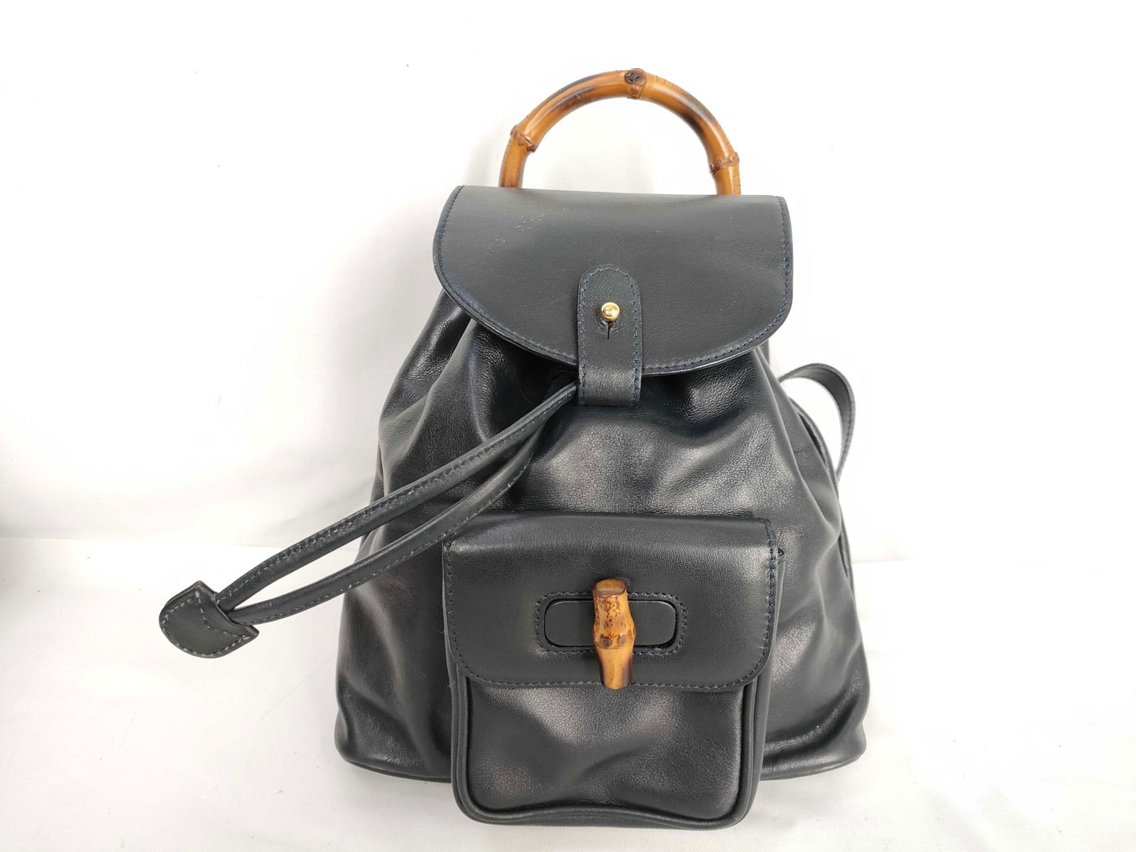 Gucci Bamboo Backpack in Black Leather – Vintage Model: Authentic Gucci Bamboo Backpack. Classic Gucci bamboo-handled backpack crafted in smooth black leather with signature bamboo toggle closure and adjustable leather shoulder straps. Features one front f