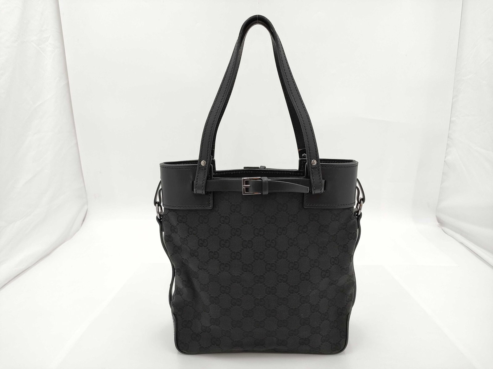 Authentic Gucci GG Pattern Canvas Tote Bag: Authentic Gucci Tote bag featuring dark canvas printed with the repeating GG pattern and trimmed with leather at the top edge, base, handles, and strap attachments. Having two leather shoulder straps
