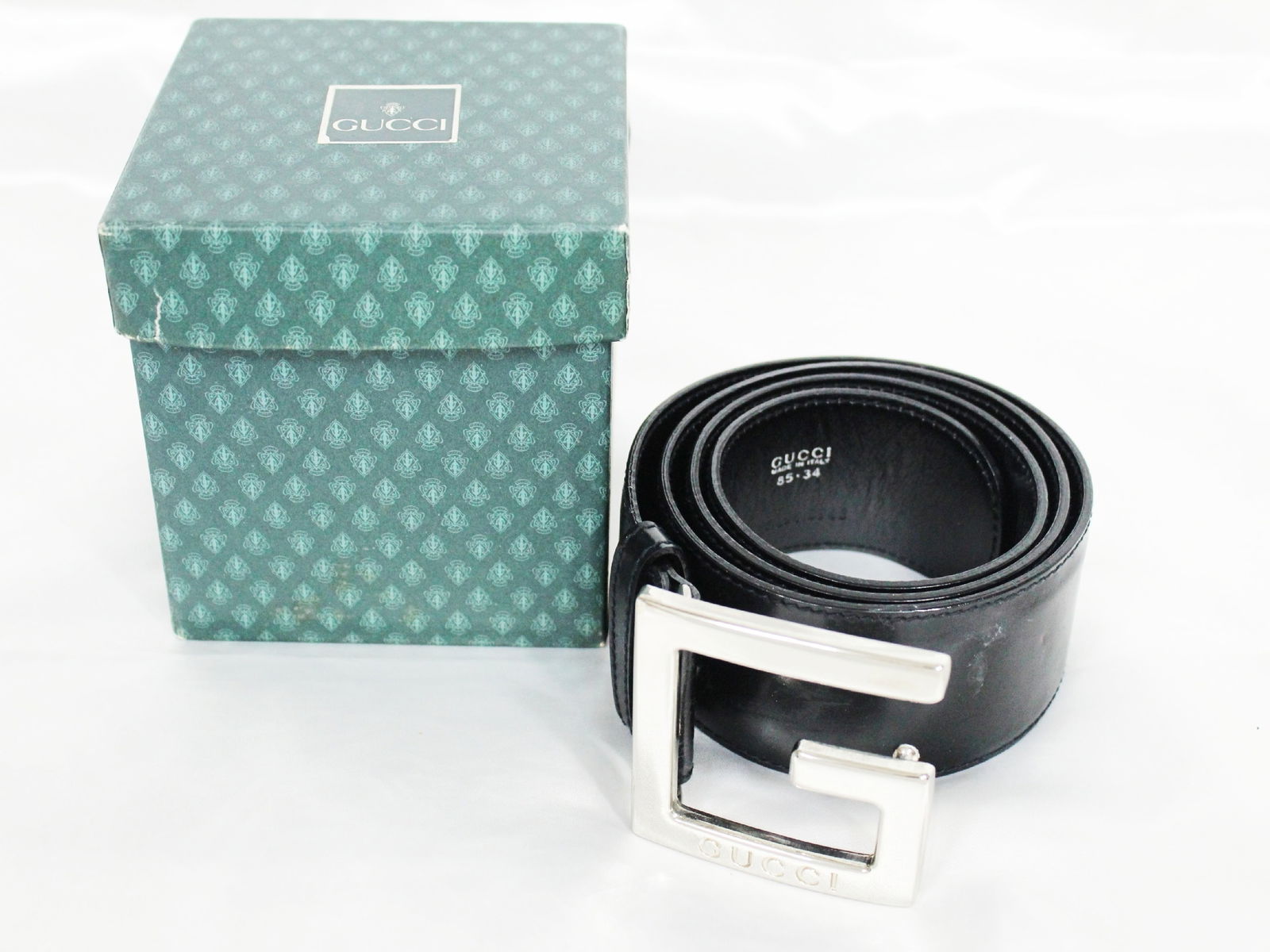 Gucci Black Leather Belt with G Buckle: Authentic Gucci Black Leather Belt with G Buckle. Belt featuring black leather with a wide strap and a polished silver-tone G-shaped buckle. Strap interior marked Gucci and Made in Italy. Belt comes