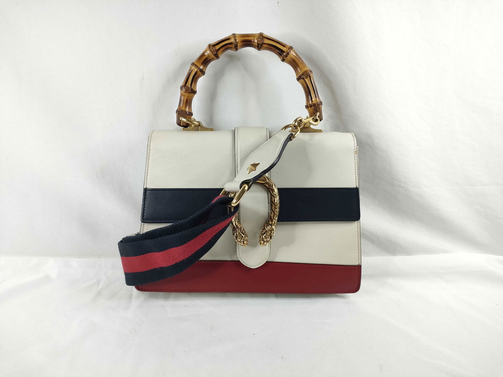 Gucci Bamboo Dionysus 2-Way Handbag: Authentic Gucci Bamboo Dionysus 2-Way Handbag featuring white leather with navy and red center stripes across the front. Designed with a bamboo top handle and the signature Dionysus textured horseshoe