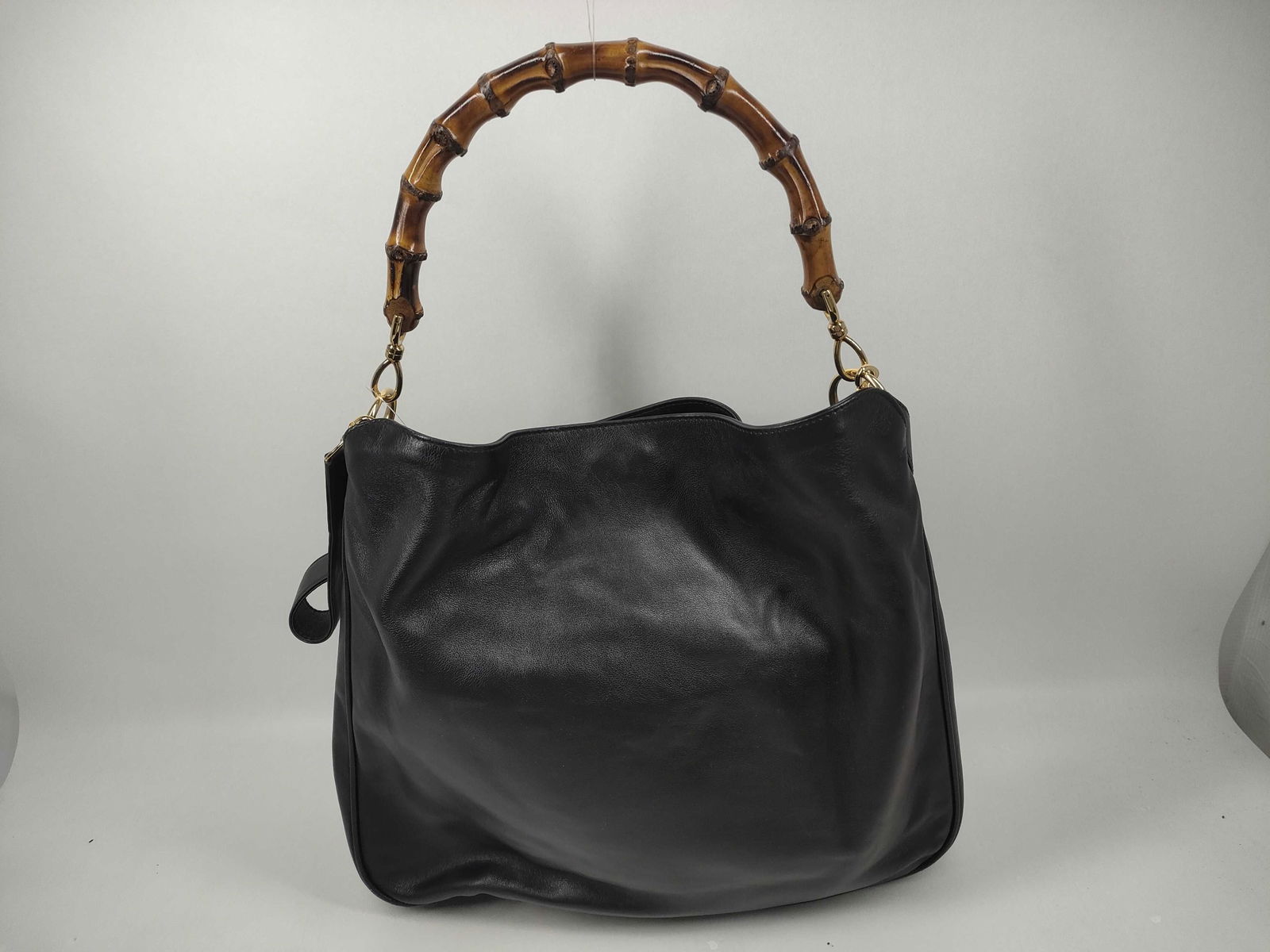 Gucci Bamboo Black Leather 2-Way Shoulder Bag: Authentic Gucci in used condition. Black leather shoulder bag having a curved silhouette featuring a signature bamboo top handle and detachable leather shoulder strap for 2-way use. Leather body fea