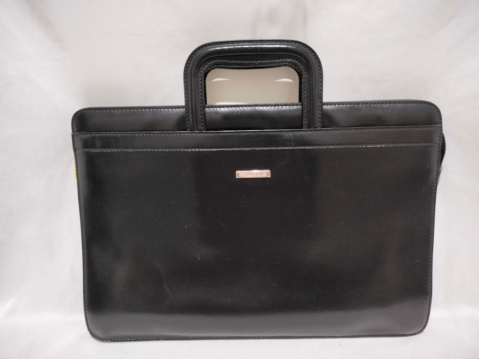 Gucci Black Leather Business Bag with Cut-Out Handles: If someone pulls this out you know they mean business. Either be afraid or be thankful they're on your side. Authentic Gucci Black leather business bag having a structured rectangular form featuring c
