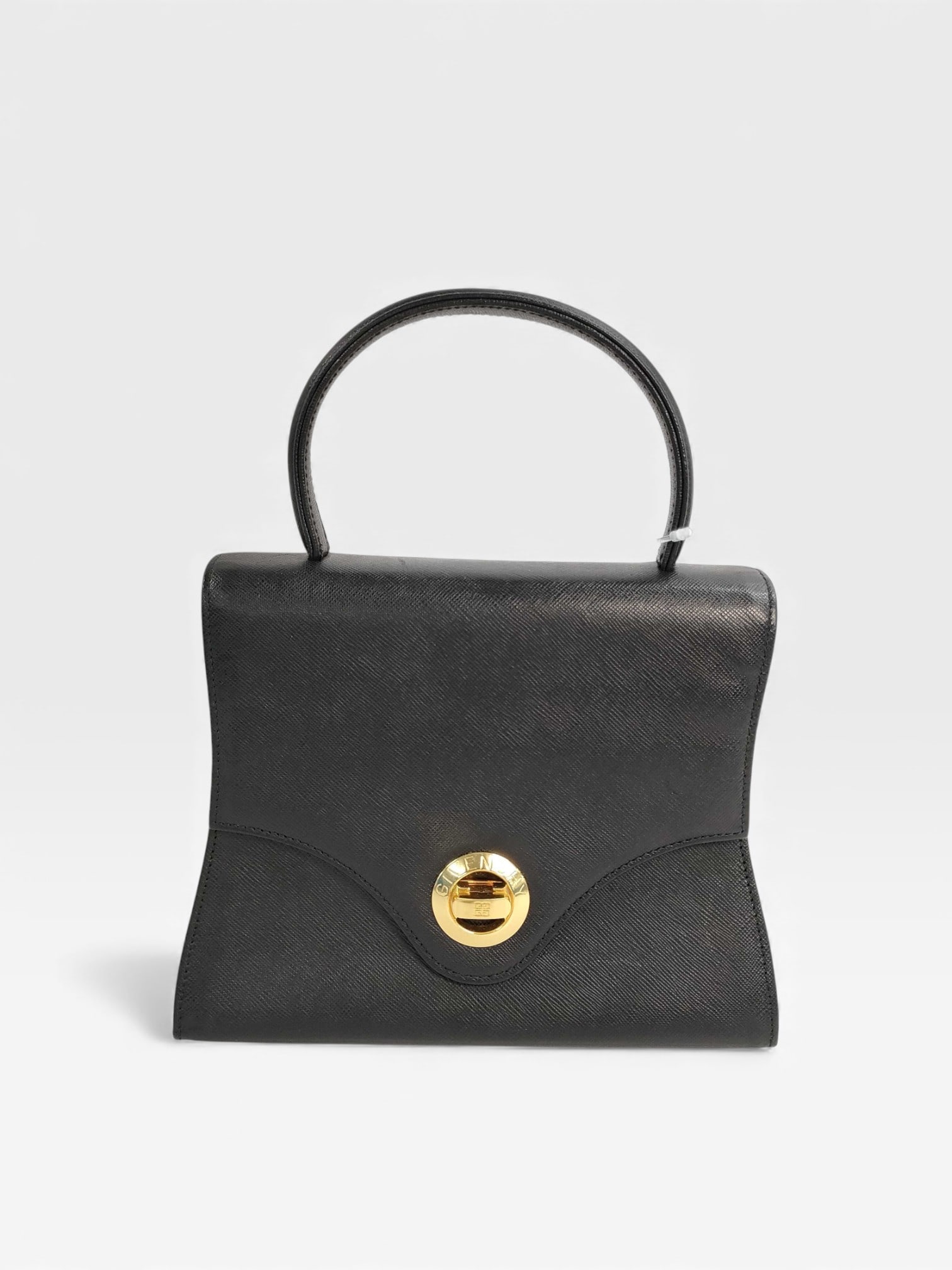 Vintage and Classic Givenchy Black Leather top-handle bag with gold-tone hardware: $700-800 online. Authentic Givenchy black leather turnlock bag. Four feet. vintage Givenchy black leather top-handle bag with gold-tone hardware. It features a distinctive structured silhouette and a