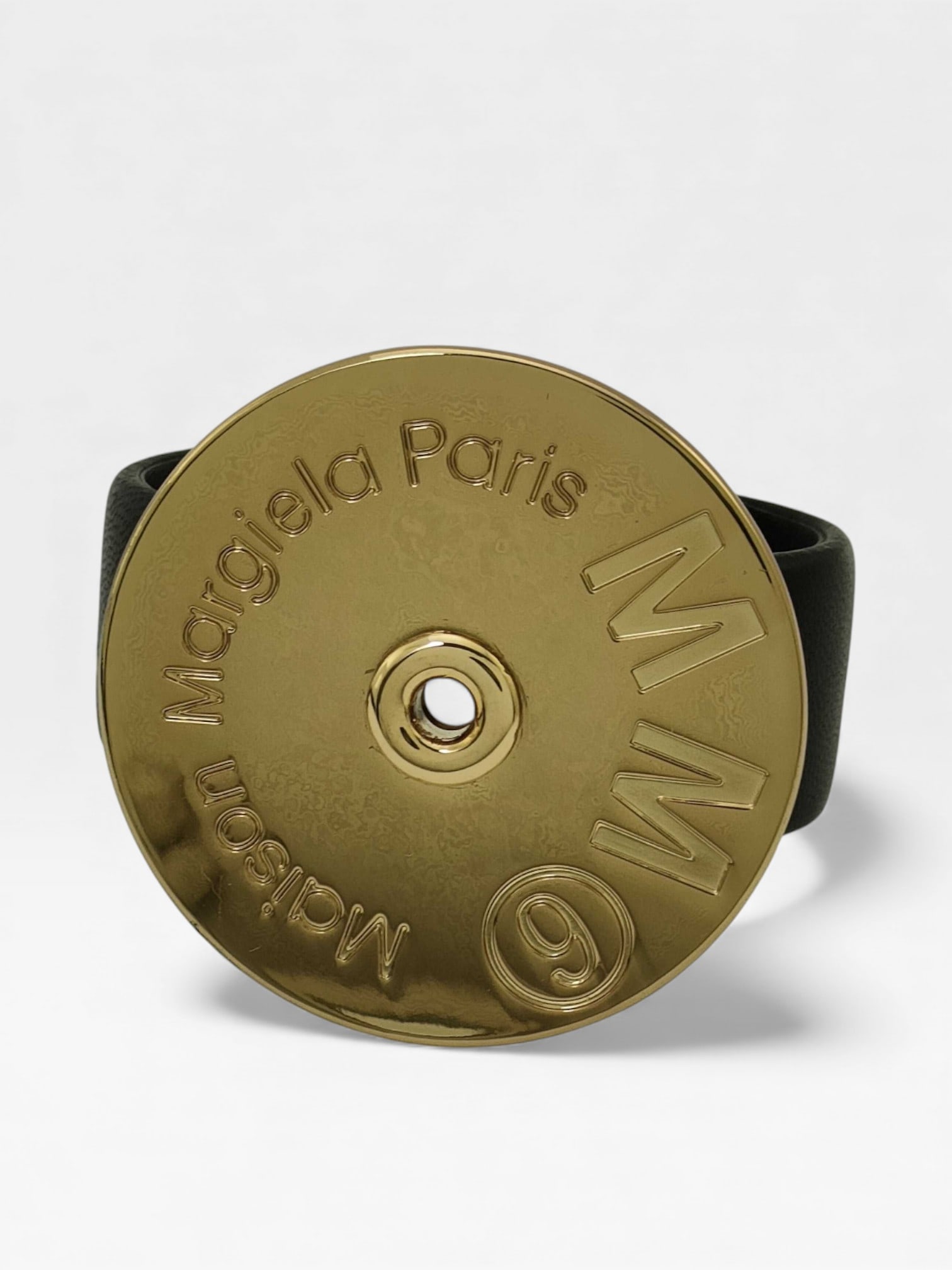 Margiela MM6 Black Leather Bangle Bracelet w/ Figural Logo Rivet Medallion: Margiela MM6 Black Leather Bangle Bracelet w/ Figural Logo Rivet Medallion. It looks like the back of ammo casing, I know they are going for that. This could fit a variety of wrists with its open back