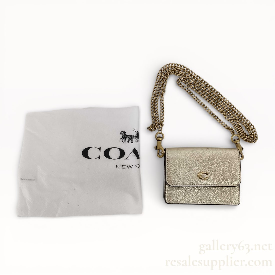 Coach Chain Wallet on Chain in Shimmery Champagne Leather - Like New: Coach wallet-on-chain bag having pebbled leather construction in a light neutral tone. Structured flap front secured with a snap closure featuring a metal Coach logo. Detachable gold-tone chain strap