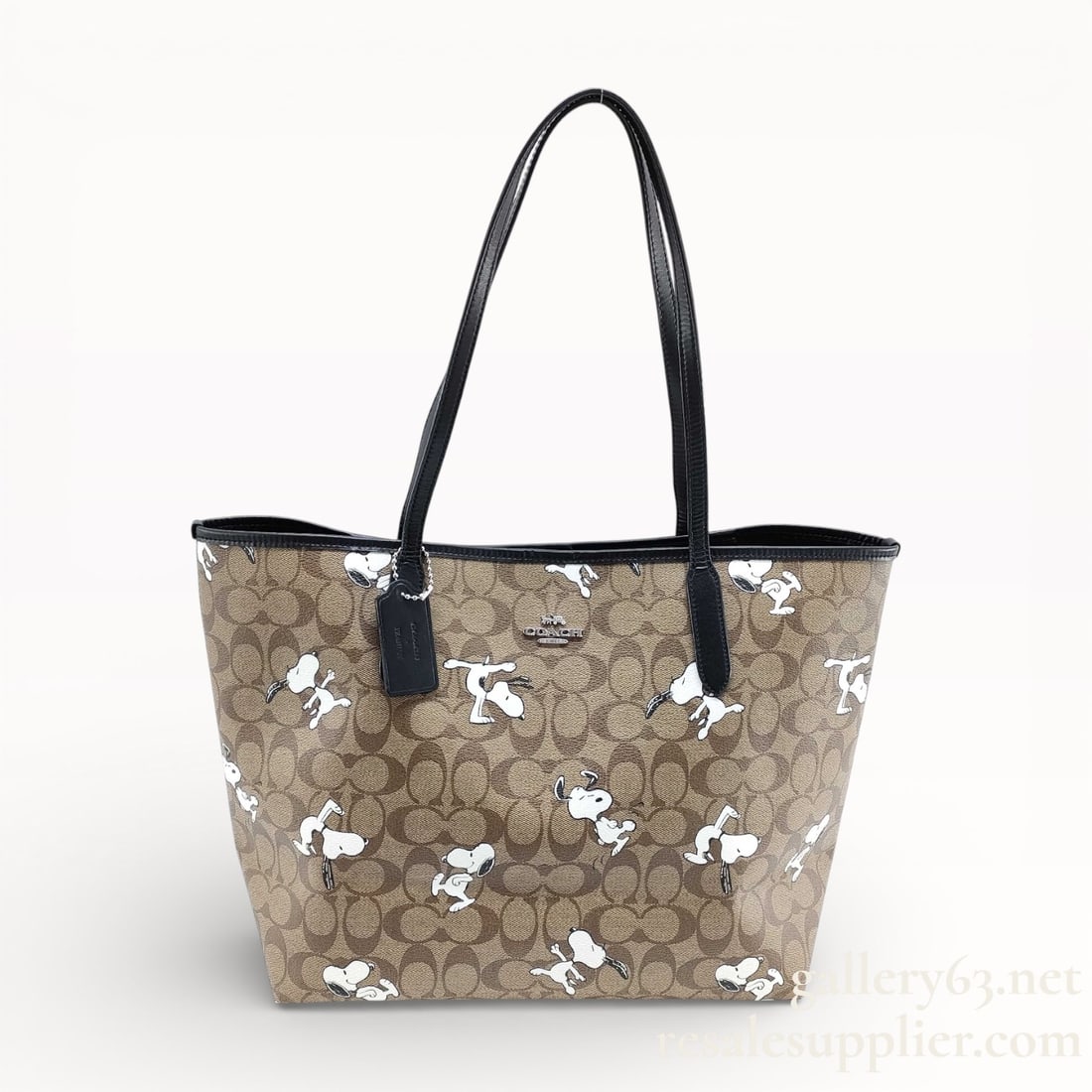 Coach Signature Snoopy Tote Bag Authentic: Authentic Coach tote bag having signature coated canvas construction with allover logo pattern. Exterior printed with repeated Snoopy character motifs throughout. Trimmed with black leather at the top