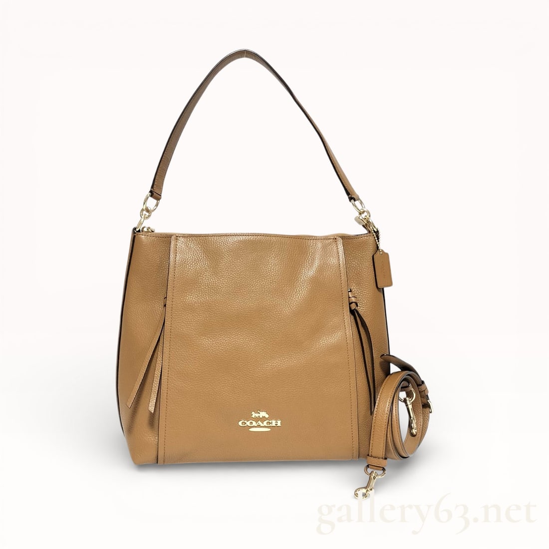 Coach Tan Leather 2-Way Shoulder Bag: Coach shoulder bag crafted of tan leather. Bag having a soft rectangular silhouette with a single leather shoulder strap and detachable longer strap for crossbody wear. Front featuring a small metalli