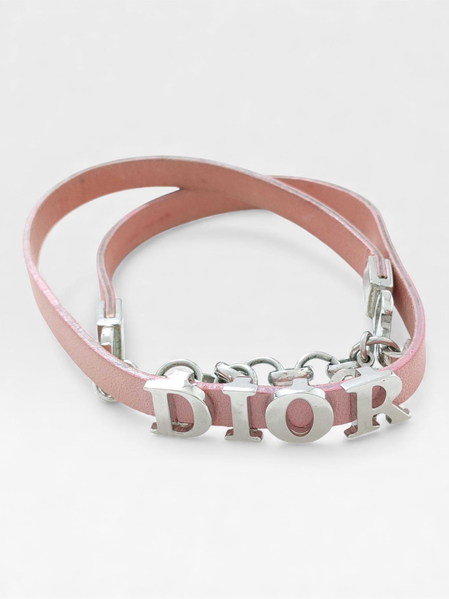 Dior Pink Leather Charm Bracelet Bangle: Dior pink leather double wrap bracelet with palladium tone Dior charm logo. Fits a 6.5" wrist.