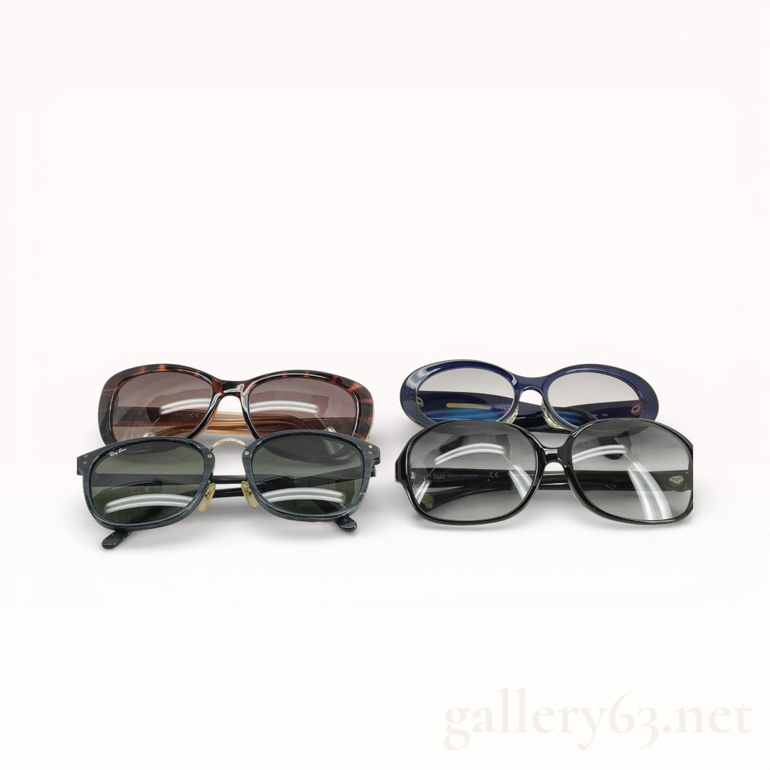 Designer Sunglasses Set of Four - Dolce & Gabbana, Salvatore Ferragamo, Ray-Ban, Guess: Assorted designer sunglasses set consisting of four pairs. Mixed frame styles including rectangular and rounded shapes. Frames in assorted colors including tortoiseshell, black, and blue. Lenses in as