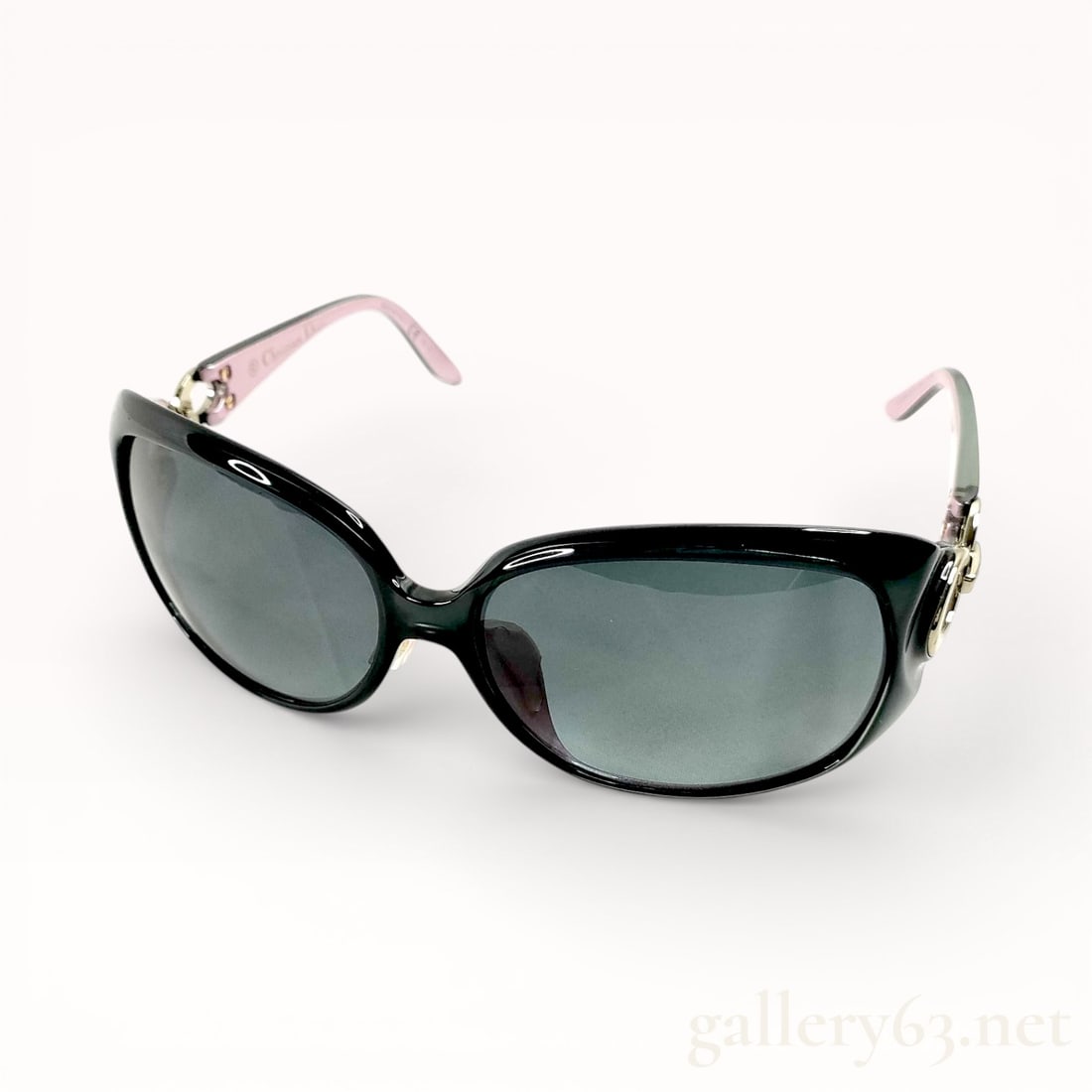 CHRISTIAN DIOR LADY DIOR GLOSSY BLACK & PINK ACETATE SUNGLASSES: Dior sunglasses featuring a black, slightly cat-eye shaped plastic frame. Lenses having a dark gray tint. Temples in a contrasting pale tone with decorative metal hinge accents near the frame. Integra