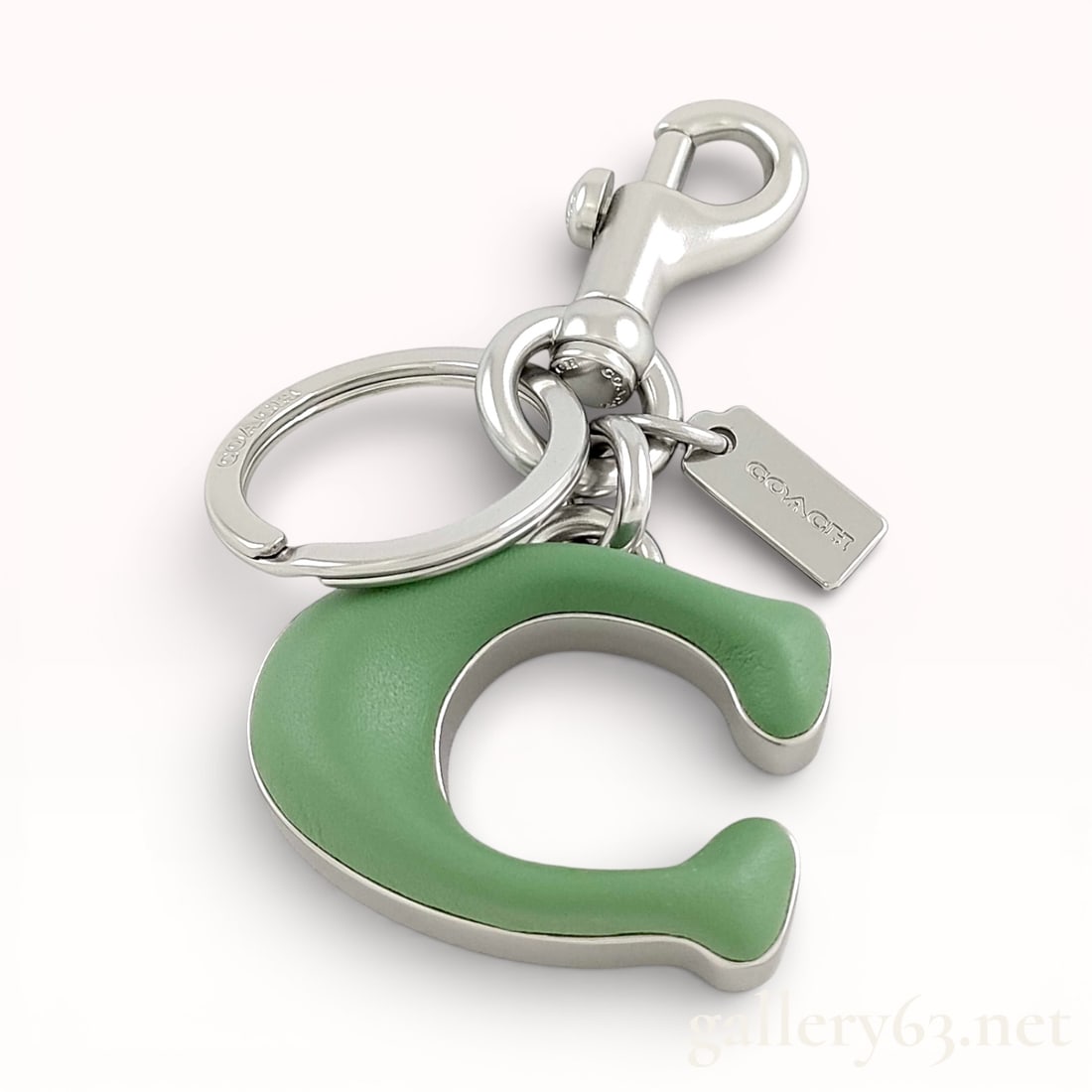 Coach Signature C Jumbo bag charm in pale pistachio leather and palladium-tone metal: Authentic Coach key ring and key chain featuring a leather-wrapped “C” motif charm in green tone. Piece fitted with silver-tone hardware including a swivel clasp and split key ring. Coach logo