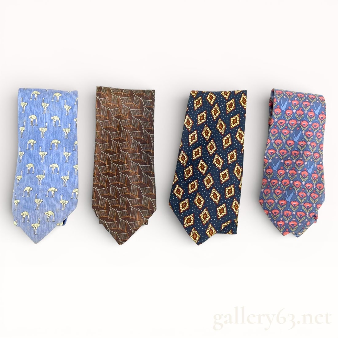 Hermès and Chanel Silk Tie Set of Four: Mixed-brand tie set featuring four silk neckties by Hermès and Chanel. Ties presented in varied colorways and patterns, including light blue with small repeating motifs, brown with geometric patterni