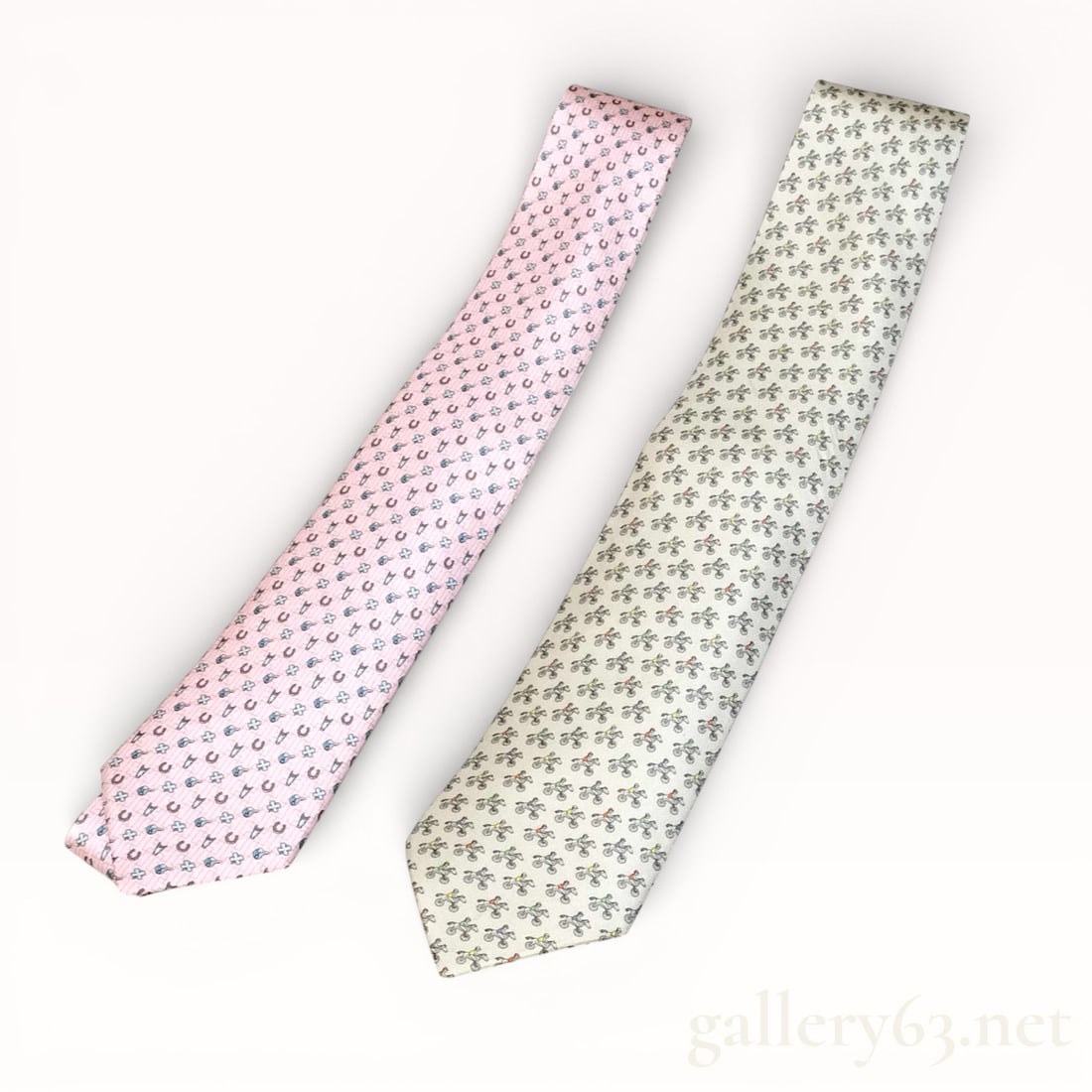 Hermès All-Over Pattern Silk Tie Set of Two: Hermès tie set featuring two silk neckties, each woven with an all-over repeating motif. One tie presented in a light pink ground with small repeating motif, and one tie presented in a light neutral