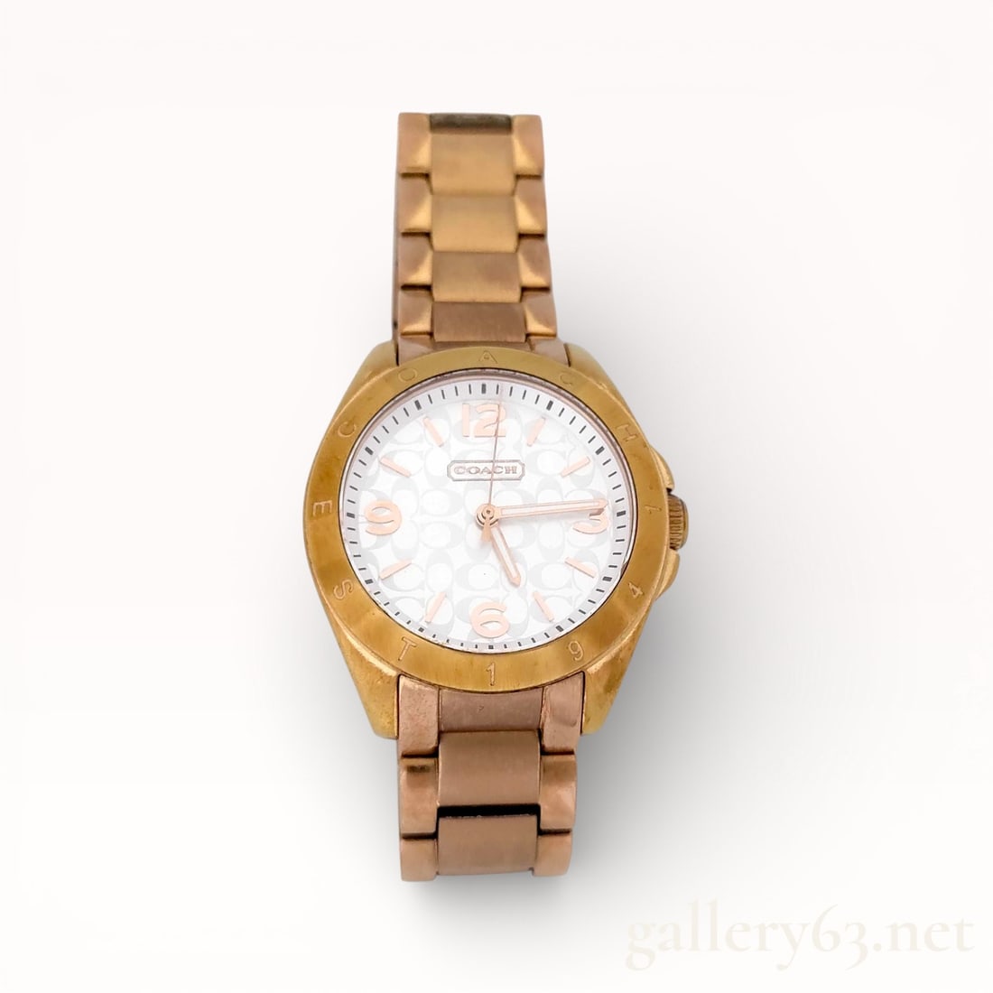Coach Signature Gold-Tone Ladies Quartz Bracelet Watch: Authentic Coach Coach ladies wristwatch featuring a gold-tone metal case fitted with a signature monogram dial. Dial having applied hour markers, central hands, and signed Coach branding. Quartz
