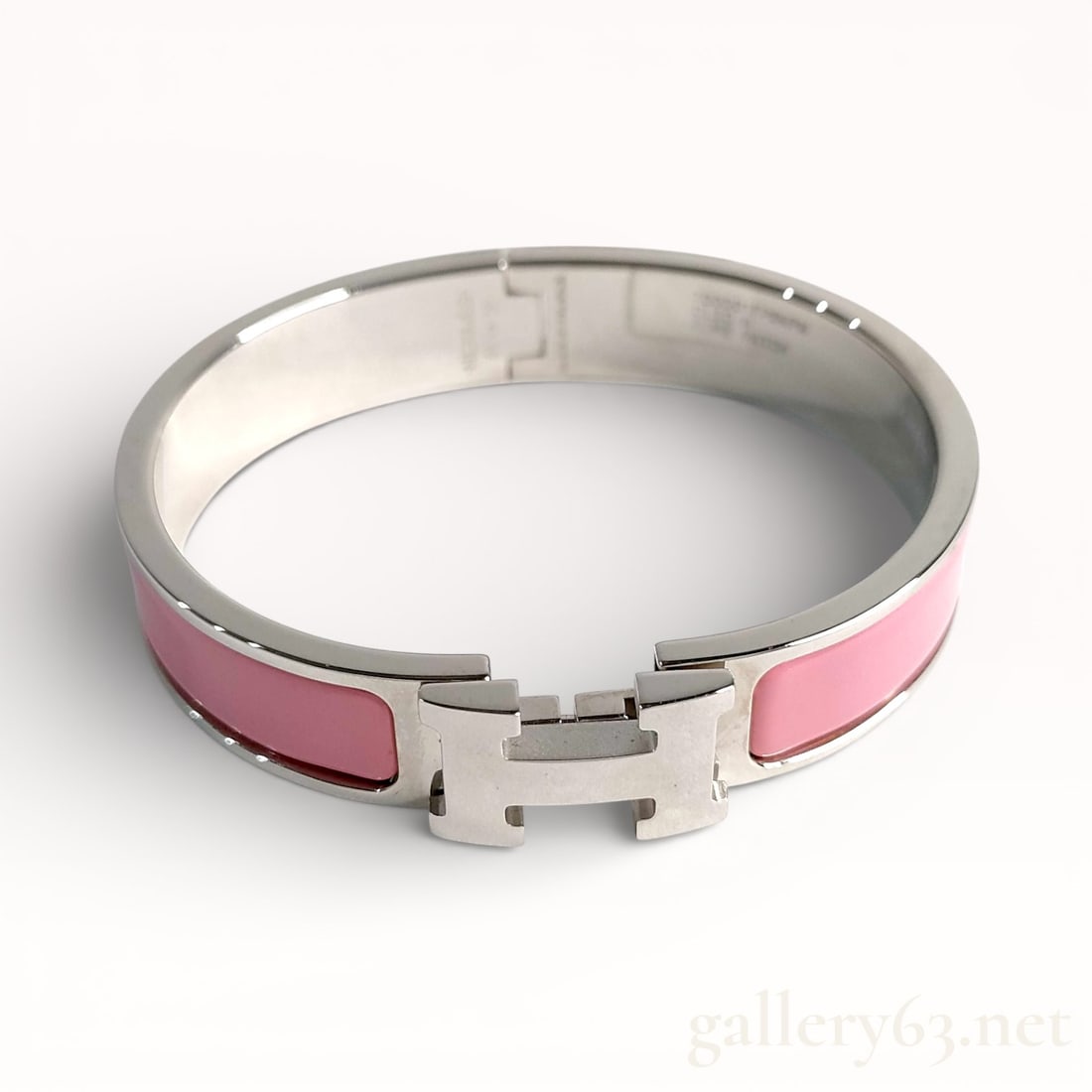 Hermès Clic H enamel and palladium-plated metal bracelet in pink: Authentic Hermès bangle bracelet having a polished silver-tone metal structure with inset pink enamel panels. Hinged construction featuring an H-shaped clasp closure at the front. Smooth interior