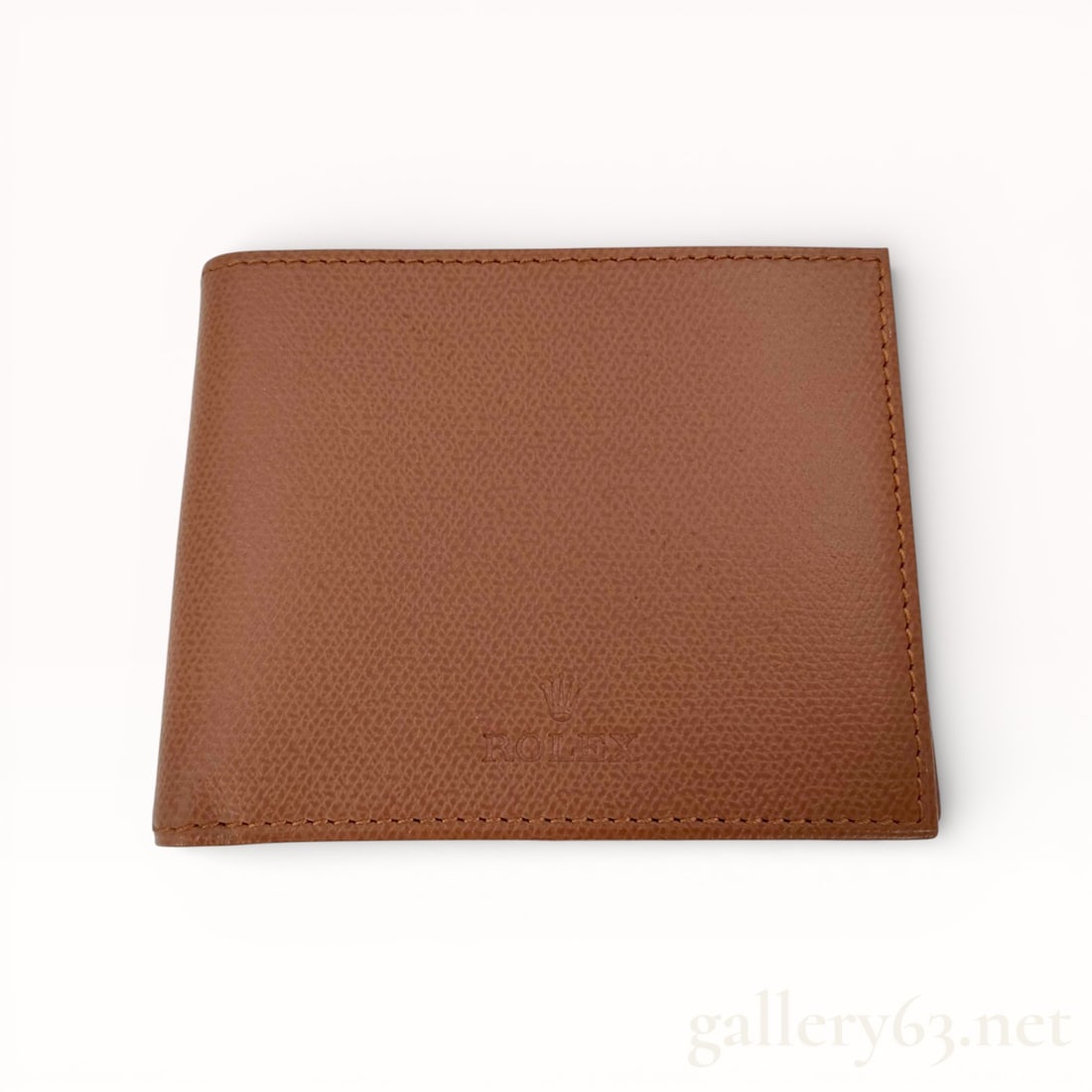 Rolex Brown Leather Bifold Wallet: Rolex wallet featuring a brown leather exterior with a fine pebbled texture. Bi-fold construction opening to a slim interior layout for cards and paper currency. Front subtly embossed with the Rolex c