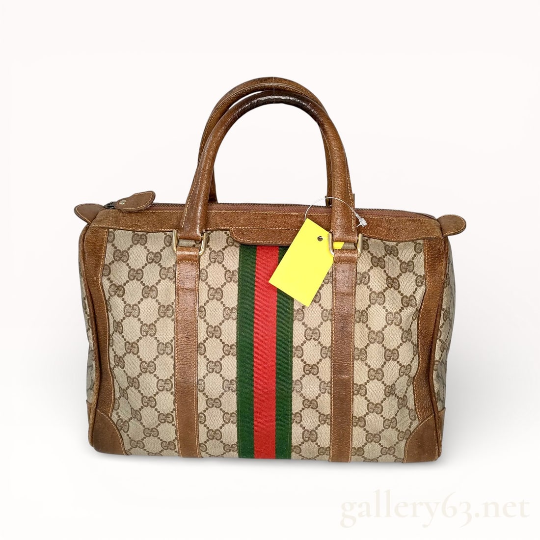 Gucci Vintage GG Canvas Boston Bag with Sherry Stripe: Authentic Vintage Gucci Boston bag crafted in beige GG monogram canvas featuring the iconic green and red Sherry web stripe centered on the front and back. Structured silhouette trimmed in brown leath