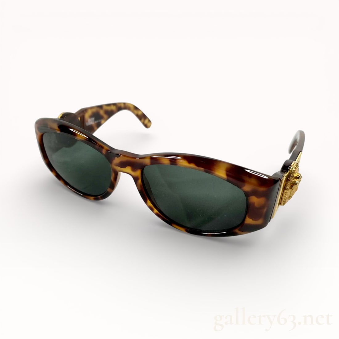 Versace Tortiseshell Gold Medallion Medusa Sunglasses: Authentic & iconic Versace sunglasses having dark green-tinted lenses set within a brown tortoiseshell-pattern acetate frame. Oval lens shape with softly curved profile. Acetate temples continuing the