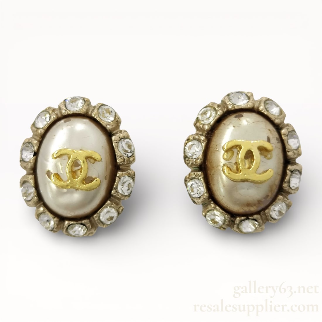 Chanel 08A Faux Pearl CC Rhinestone Clip Earrings: Authentic Chanel clip earrings from the 08A collection having oval faux pearl centers set with raised gold-tone CC logos. Design framed by a border of clear rhinestones in gold-tone metal. Clip-back