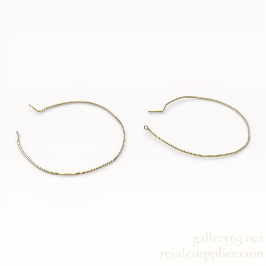 AHKAH 10K Gold Hoop Earrings: AHKAH earrings having a minimalist open hoop form crafted in K10 yellow gold. Slender wire construction forming an elongated oval silhouette. Hook-style closure with integrated ear wire. Lightweight