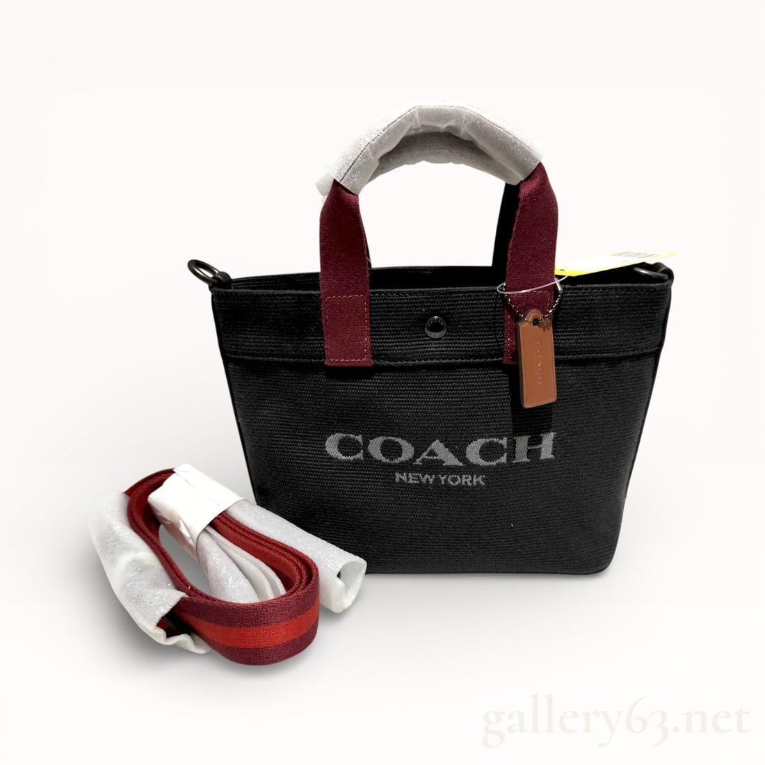 Coach CU299 Two-Way Canvas Handbag with Shoulder Strap: Authentic Coach two-way handbag having a structured tote form constructed in black canvas featuring a contrasting Coach New York logo print at front. Dual top handles executed in contrasting fabric