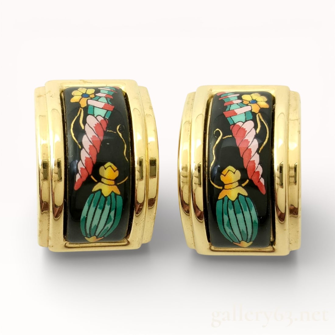 Hermès Émaille Enamel and Gold-Tone Earrings with Box Les Flacons: Authentic Hermès Gold-tone earrings having a curved hinged form set with black enamel panels. Enamel surfaces decorated with stylized floral and botanical motifs in green, yellow, red, and blue