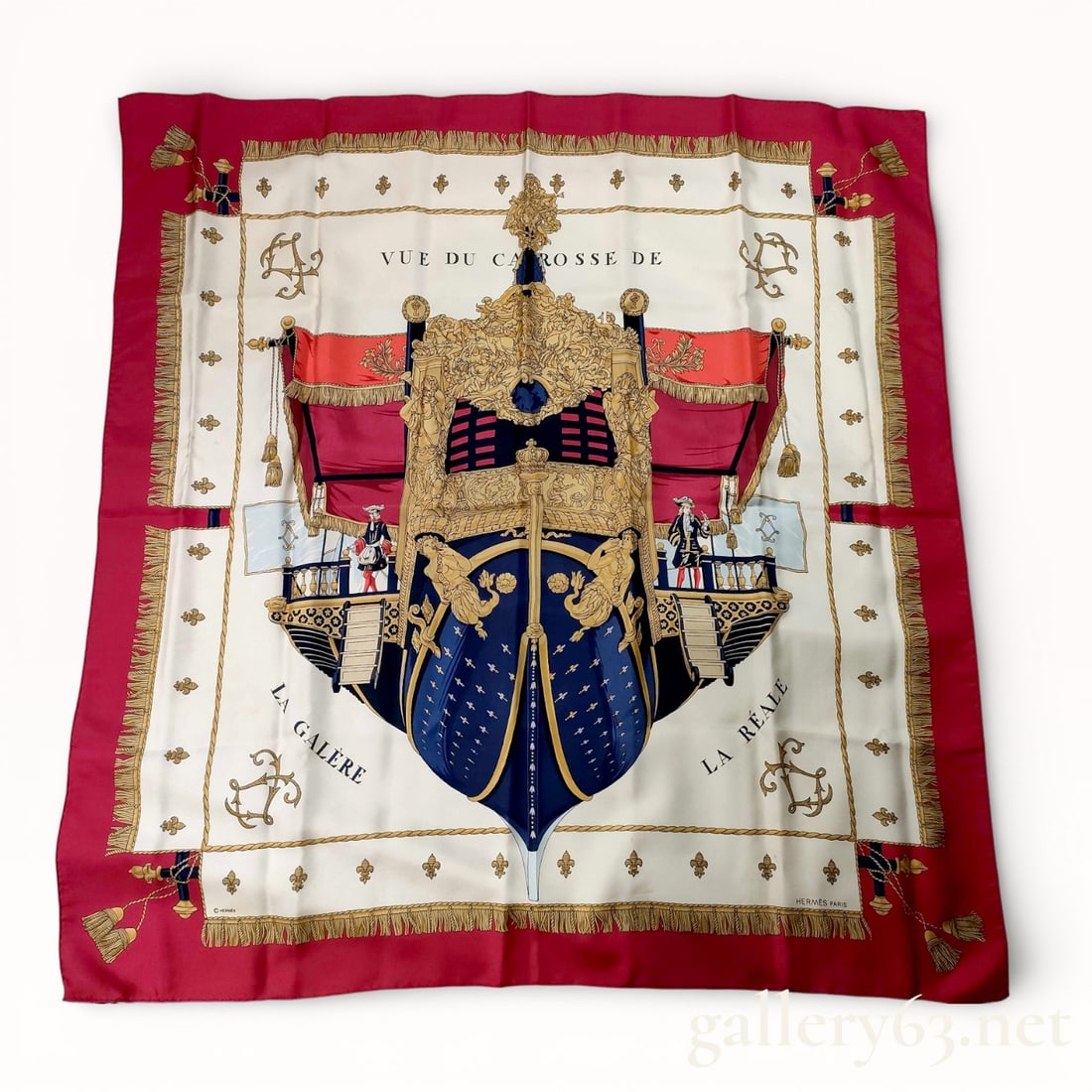 Hermès Vue du Carrosse de la Galerie Silk Carré 90 Scarf: Hermès silk carré 90 scarf featuring the Vue du Carrosse de la Galerie design, rendered in red, cream, navy, and gold tones. Central composition presents an ornate ceremonial carriage with architect