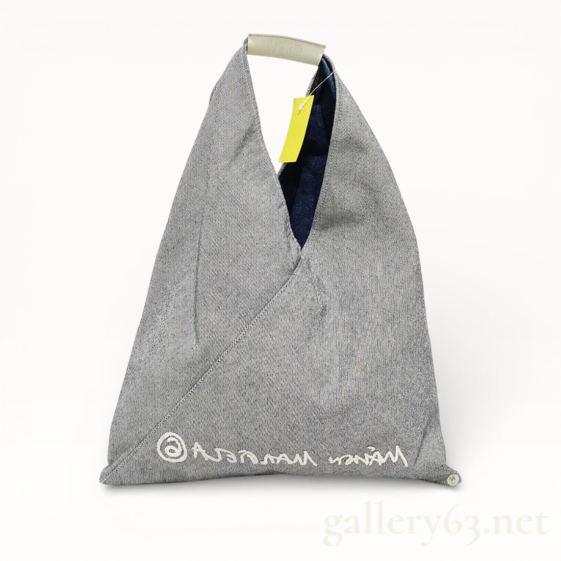 MM6 Maison Margiela Reversible Grey Denim Small Triangle Tote: Authentic MM6 Maison Margiela Japanese denim tote bag. Non-stretch denim tote in grey. Integrated carry handle with logo-embossed leather strap pad in white at top. Logo embroidered in white at face.