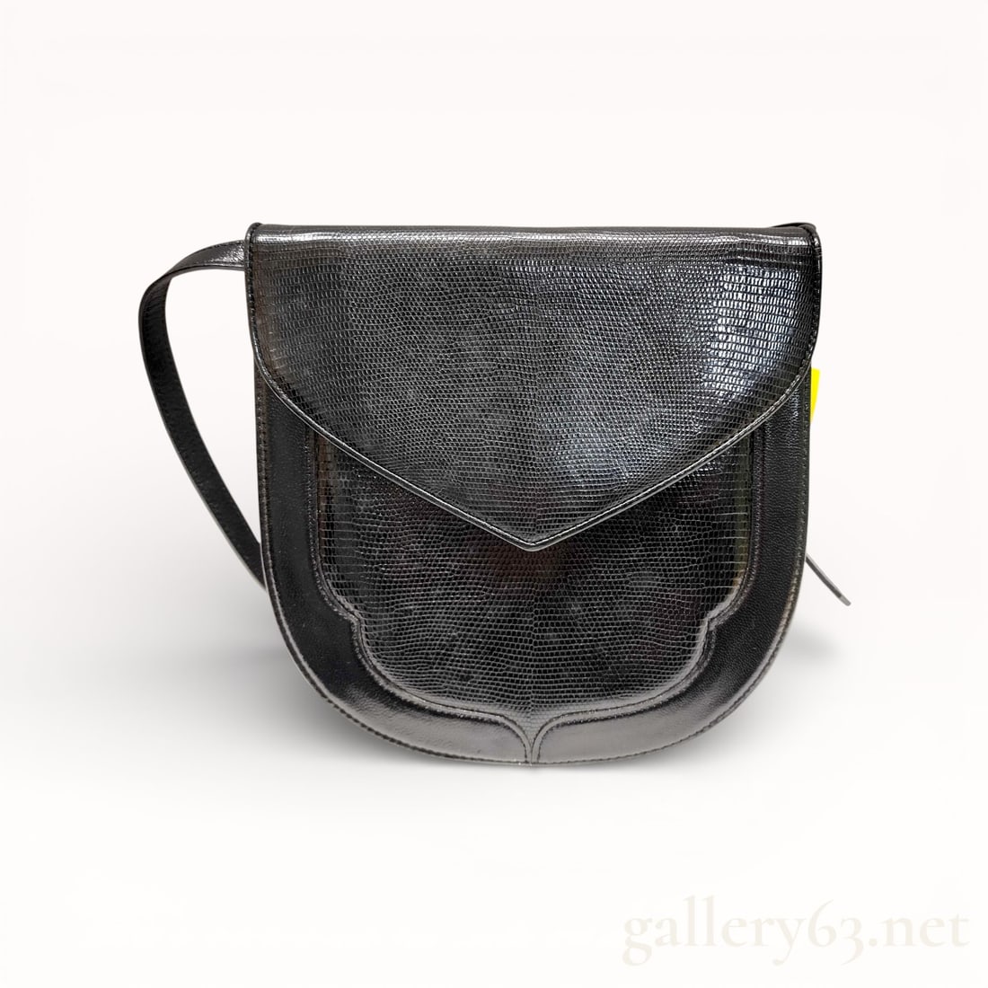 Yves Saint Laurent Lizard Leather Black Shoulder Bag: Authentic Yves Saint Laurent shoulder bag having a black lizard skin leather exterior with a compact saddle-style silhouette. Front featuring a curved flap closure with stitched border detailing. Set