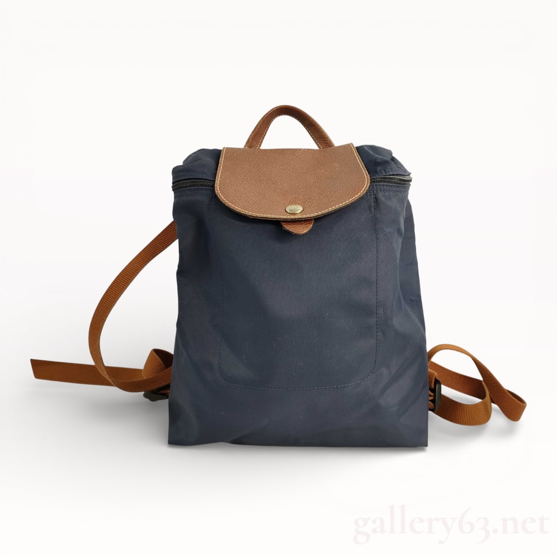 Longchamp Navy Nylon Backpack with Beige Leather Trim & Gold Hardware: Authentic Longchamp navy blue nylon construction backpack with brown beige leather trim and straps. This lovely Longchamp bag for sale at gallery63.net has gold plated hardware and is ready to be used