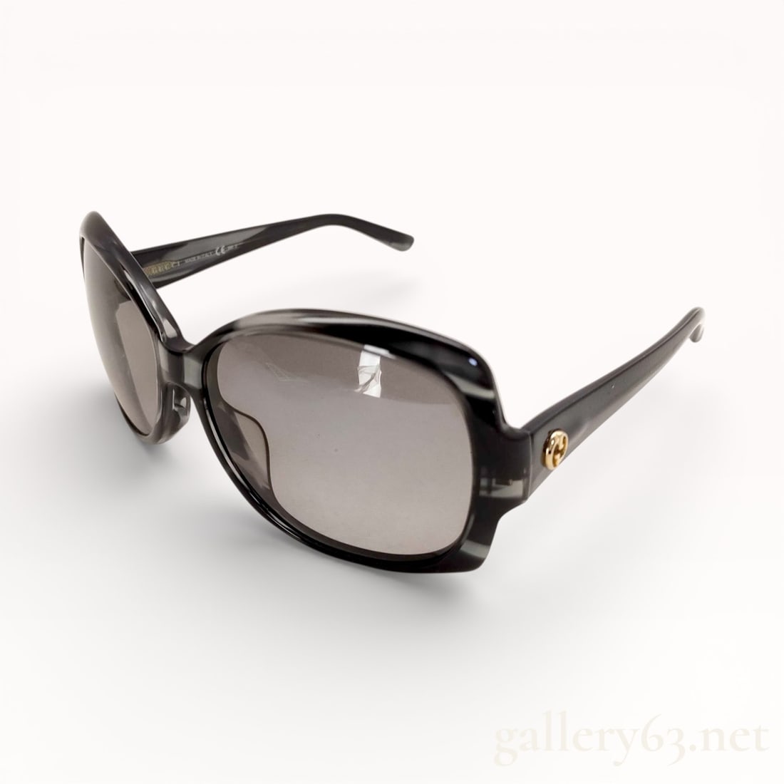 Gucci GG3596/K/S Black & Grey Glossy Gradient Sunglasses: Authentic Gucci sunglasses featuring a black plastic frame having a softly contoured rectangular shape. Dark tinted lenses set within a glossy frame front. Temples displaying gold-tone Gucci emblem ha