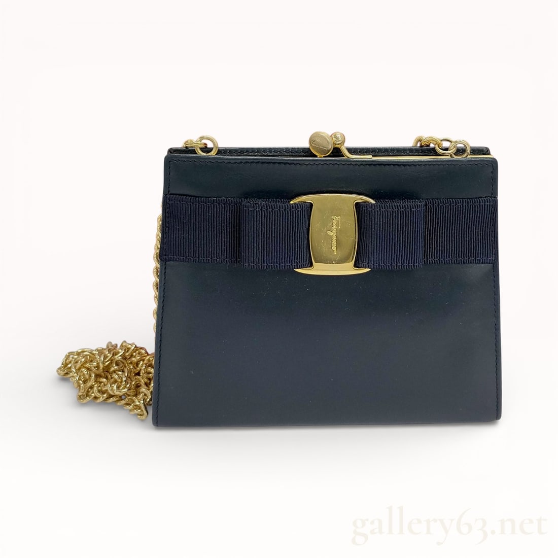 Salvatore Ferragamo Vara Chain Shoulder Bag: Authentic Salvatore Ferragamo shoulder bag having a black leather exterior. Featuring a structured rectangular silhouette with a front Vara bow detail set with a gold-tone Gancini plaque. Designed wit