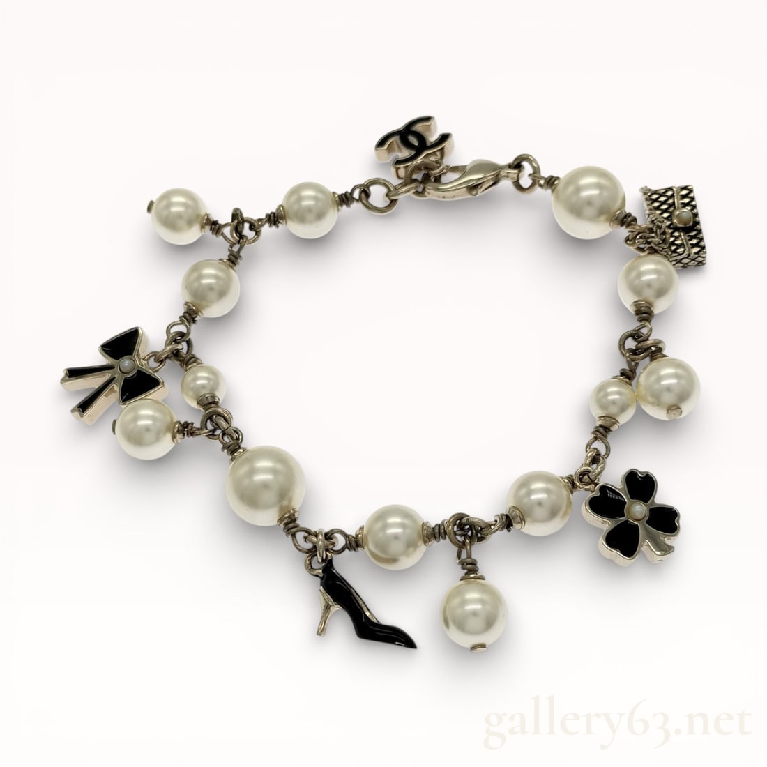 Rare 07P 2007 Spring Chanel Pearl & Enamel Charm Bracelet: Authentic Chanel Charm bracelet featuring a strand of round faux pearls linked with silver-tone metal connectors. Design set with hanging Coco-themed charms including a black enamel high-heel shoe, fl