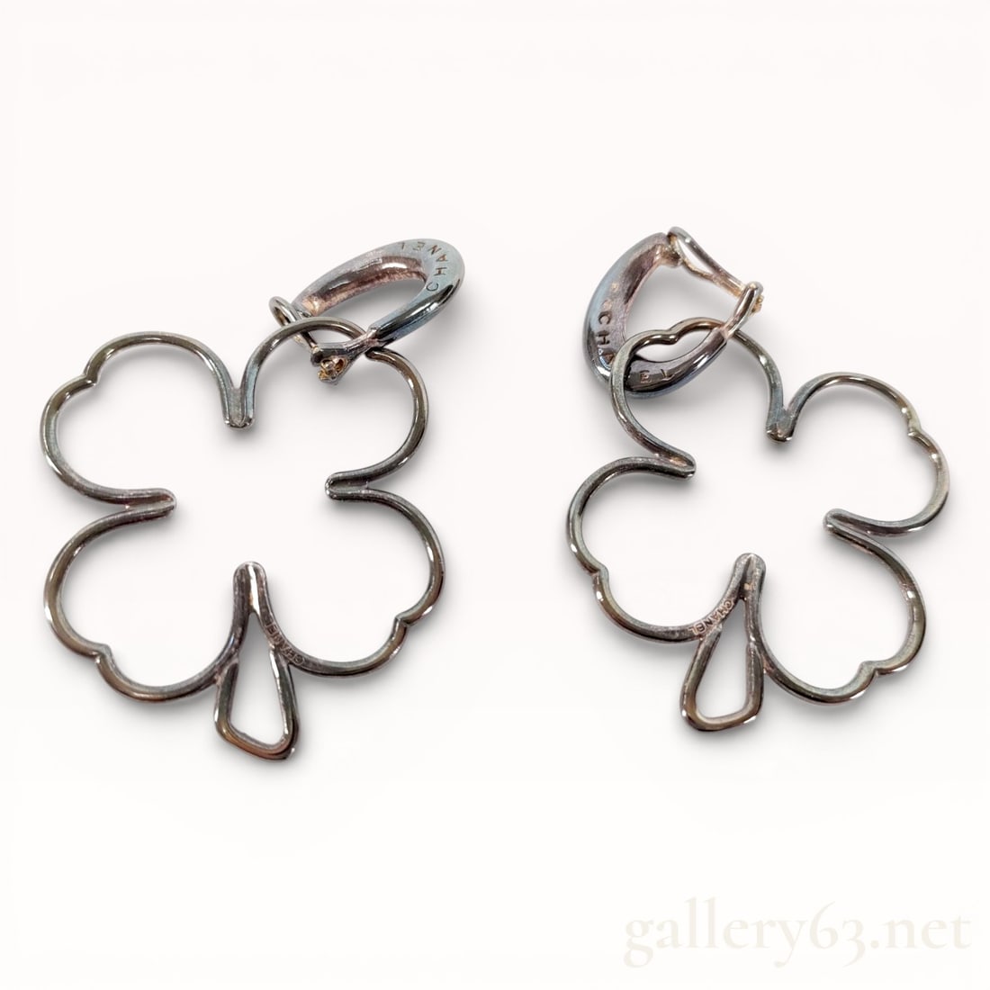 Rare Chanel Solid Sterling Silver Clover Drop Earrings: Authentic Chanel Pair of sterling silver earrings featuring openwork four-leaf clover motifs. Clover forms rendered in continuous silver wire outlining rounded petals with a small stem detail. Hinged