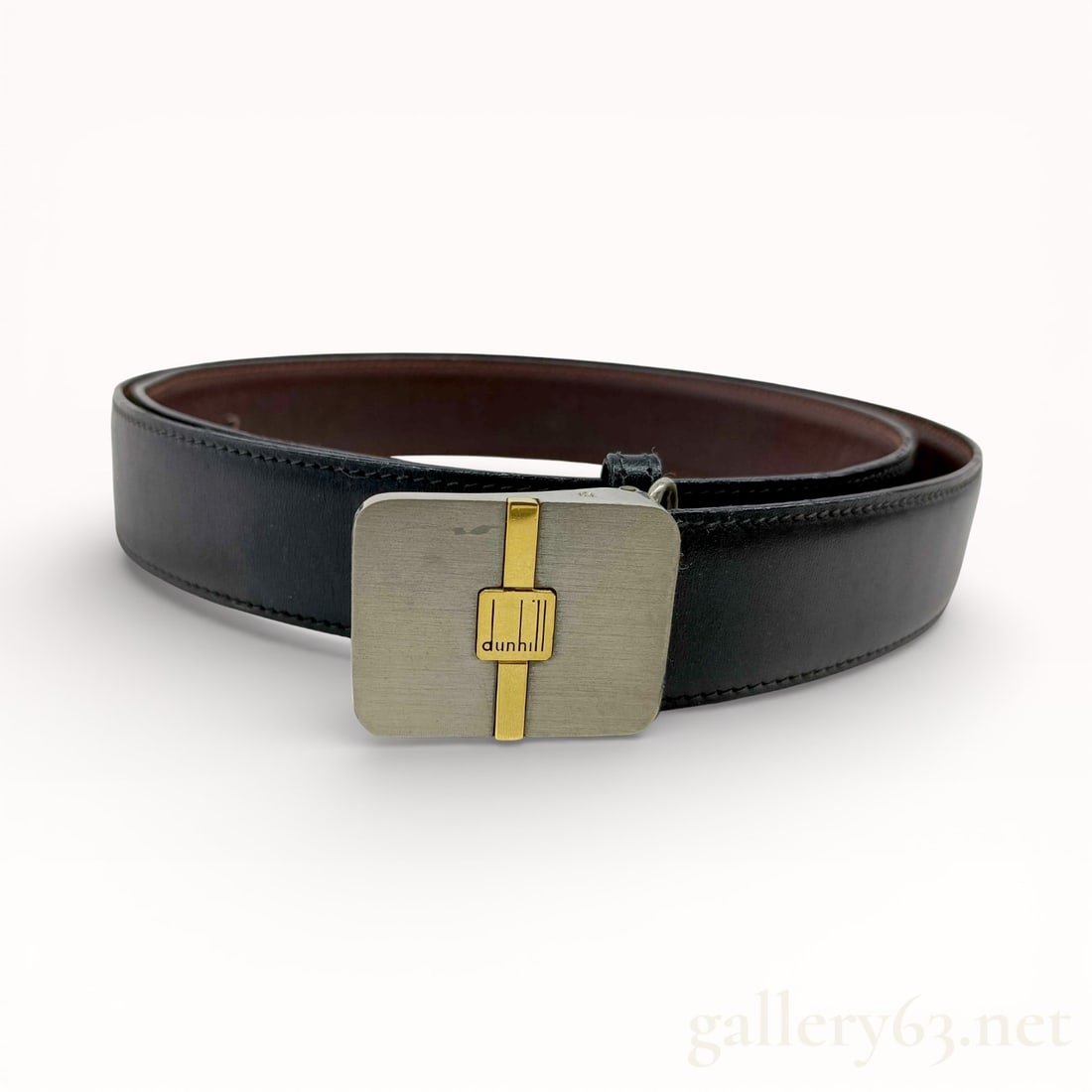 Dunhill Logo Buckle Leather Belt: Authentic Dunhill belt featuring a black leather strap with a smooth exterior finish and brown leather backing. Rectangular brushed silver-tone buckle accented by a vertical gold-tone inlay. Center pl