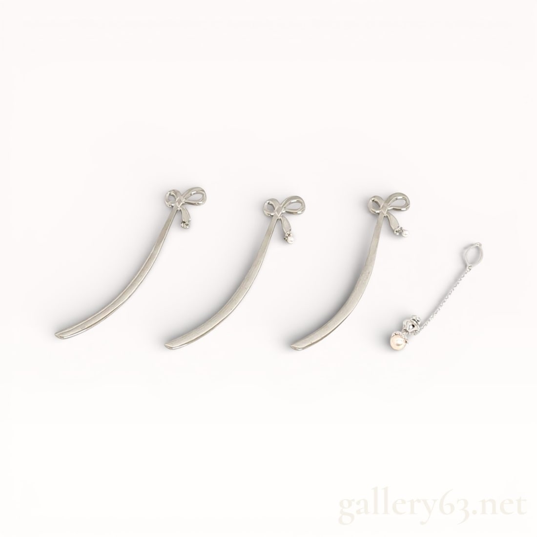 Mikimoto Shiori Pearl Pin Brooch Set: Mikimoto Shiori pin brooch set composed of three curved sterling silver pins, each surmounted by a ribbon-form motif, accompanied by a separate delicate chain element set with a single pearl accent.