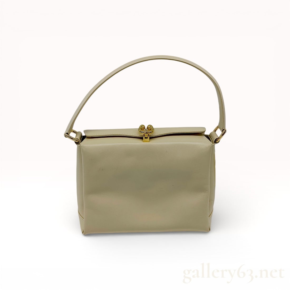Gucci Leather Handbag with Top Handle: Authentic Gucci handbag crafted in smooth leather in a light neutral tone. Structured silhouette featuring a single curved top handle and a gold-tone clasp closure at the opening. Compact body with a